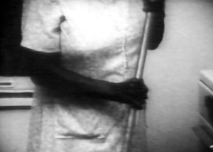 A black and white image of a person holding a mop in their hands.