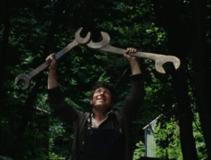 A man holds two giant spanners above his head